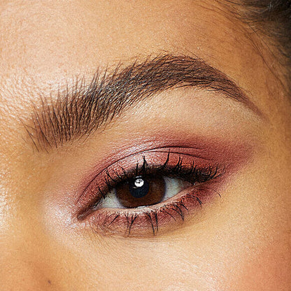 Close-up of a woman's eye with Vieve pink eyeshadow and long eyelashes.