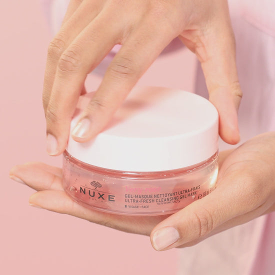 NUXE Very Rose Ultra-Fresh Cleansing Gel Mask in a jar held by hands, ideal for deep cleansing and pollution removal.