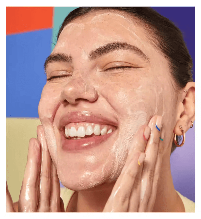 Woman smiling while applying Byoma Creamy Jelly Cleanser, showcasing its hydrating and effective cleansing properties.