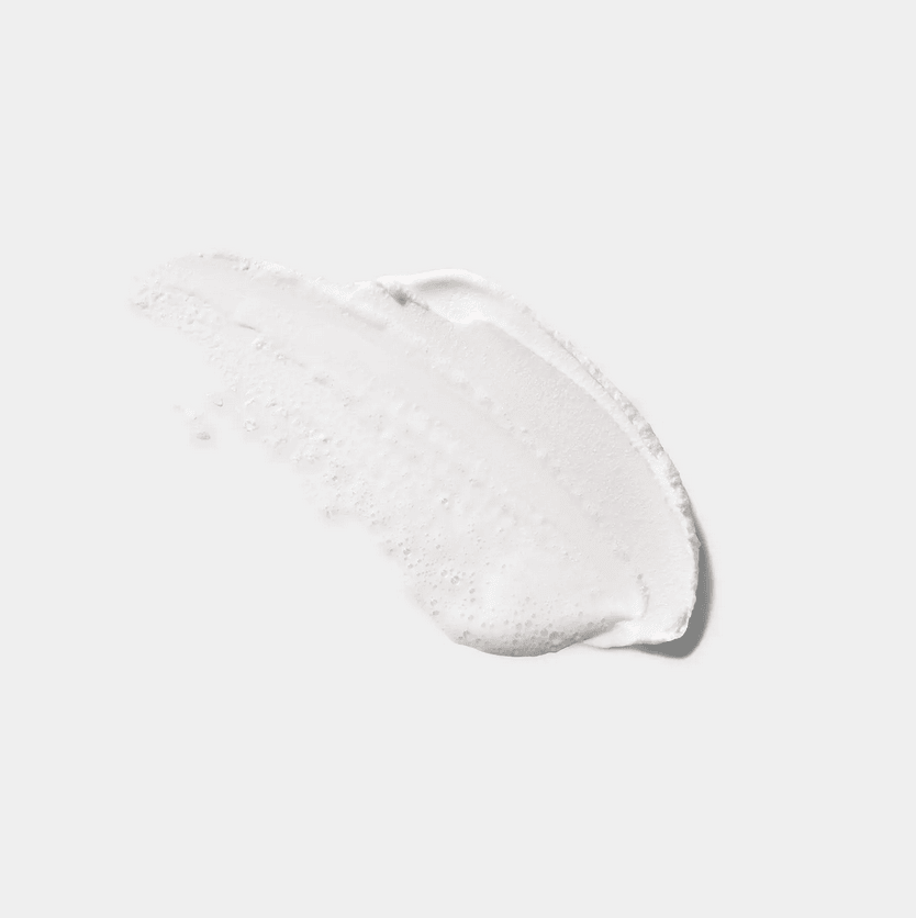 CLINIQUE All About Clean foaming facial soap texture on a clean surface, showcasing its creamy cleansing formula.