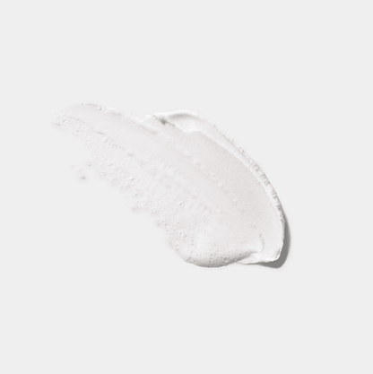 CLINIQUE All About Clean foaming facial soap texture on a clean surface, showcasing its creamy cleansing formula.