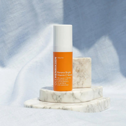 OLE HENRIKSEN Banana Bright™ Vitamin C Serum on marble platform, showcasing brightening and hydrating skincare benefits.