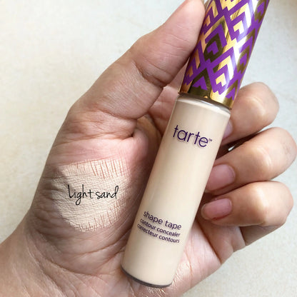 TARTE Shape Tape Concealer in Light Sand shown in hand, with blendable formula for brightening and smoothing skin.