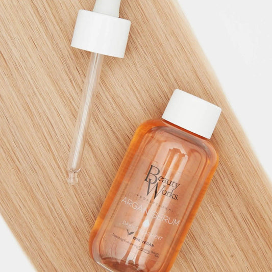 Beauty Works Argan Oil Serum 90ml bottle with dropper on wooden surface, ideal for glossy and healthy hair.