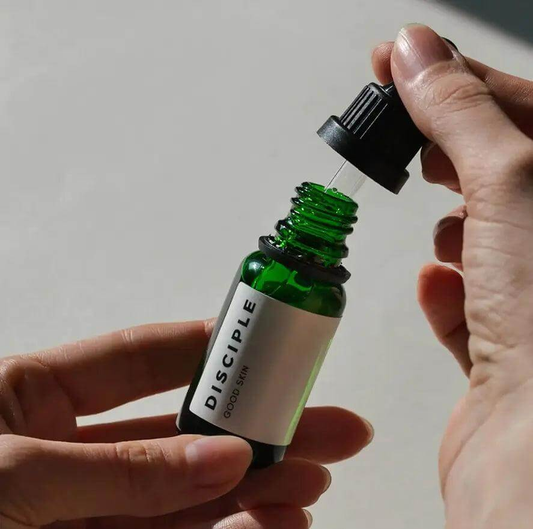 Disciple Good Skin Face Oil-Serum bottle, highlighting its green glass design and dropper for skincare use.