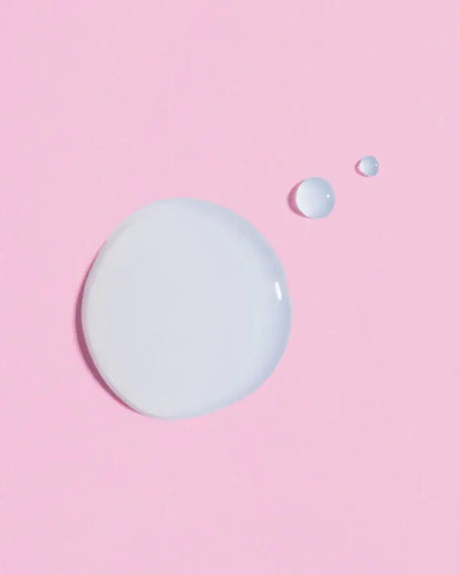 Close-up of Earth Harbor Luna Rain serum droplets on pink background, showcasing its lightweight texture.