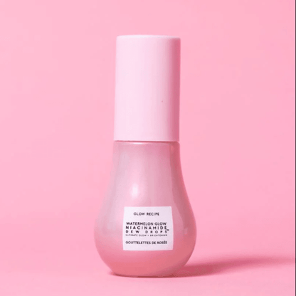 Glow Recipe Watermelon Glow Niacinamide Dew Drops highlighter bottle against a pink background, showcasing skincare and radiance.