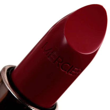 Laura Mercier Rouge Essentiel Silky Crème Lipstick in Rouge Ultime, a cool-toned medium-dark red with satin finish.
