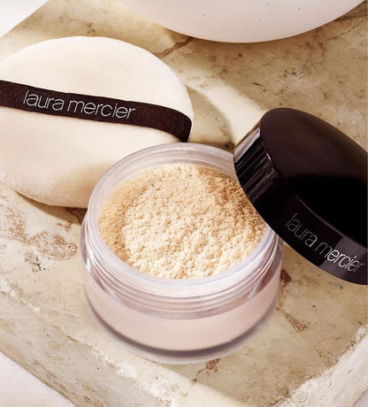 Laura Mercier Translucent Loose Setting Powder open jar with powder and puff, showcasing its glow finish and lightweight texture.