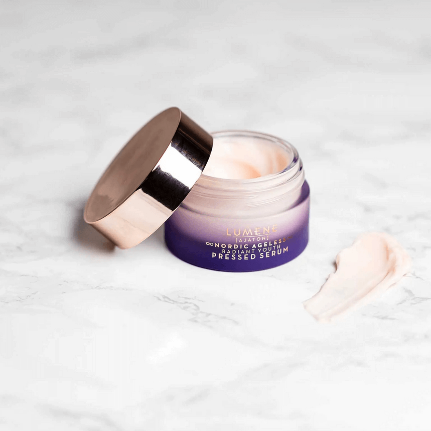 Lumene Nordic Ageless Radiant Youth Pressed Serum jar with rosy formula on marble background.