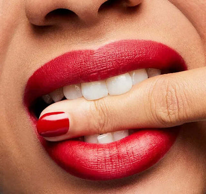 Close-up of lips wearing MAC Ruby Woo lipstick with bold matte finish and manicured red nails.