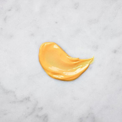 Smooth, creamy texture of Medik8 Crystal Retinal 3 Serum on a marble surface, showcasing its vibrant yellow hue.