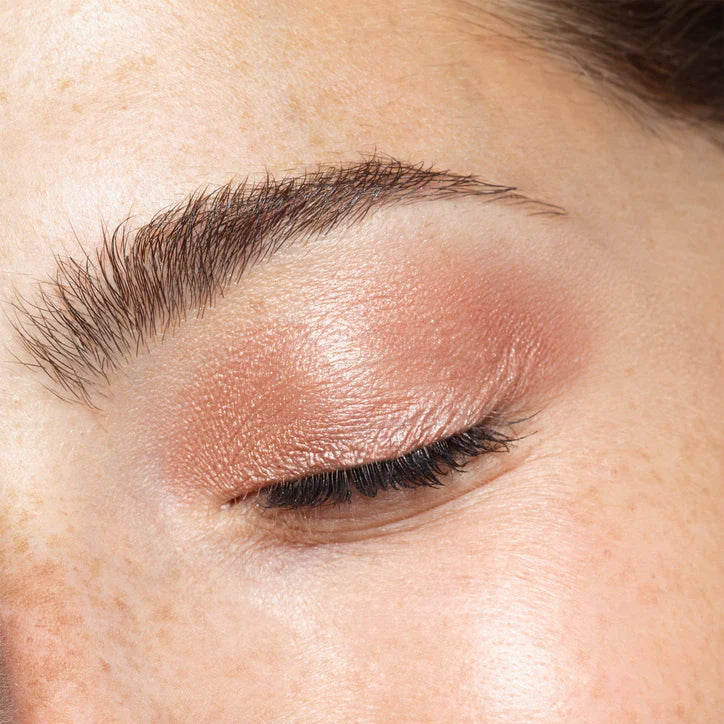 Close-up of a woman's eye showcasing shimmering nude eye makeup using NUDESTIX Magnetic Luminous Eye Colour Pencil.