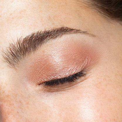 Close-up of a woman's eye showcasing shimmering nude eye makeup using NUDESTIX Magnetic Luminous Eye Colour Pencil.