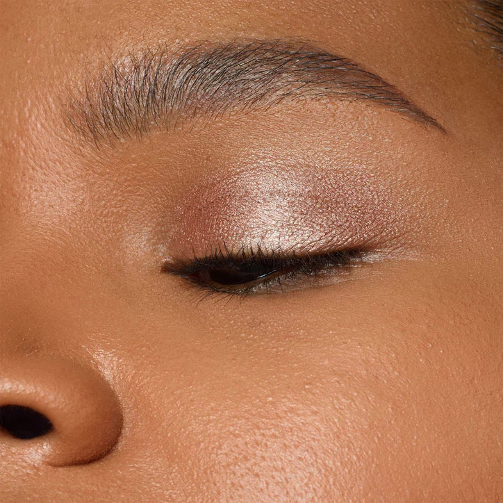 Close-up of model's eye showcasing shimmering eye makeup with NUDESTIX Magnetic Luminous Eye Colour in Nudity.