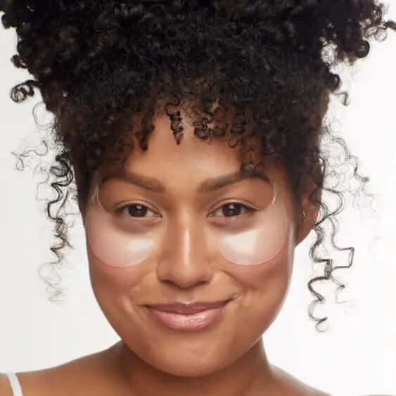 Woman using Patchology Flashpatch Rejuvenating Eye Gel masks for reducing puffiness and fatigue under her eyes.