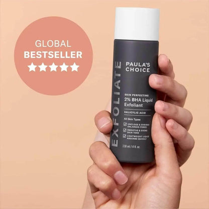 Paula’s Choice 2% BHA Liquid Exfoliant in hand, labeled as a global bestseller for smoother skin.