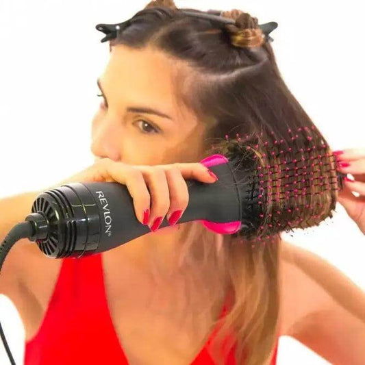 Woman using Revlon Pro Collection One Step Dryer & Volumiser for detangling and styling her hair effortlessly.