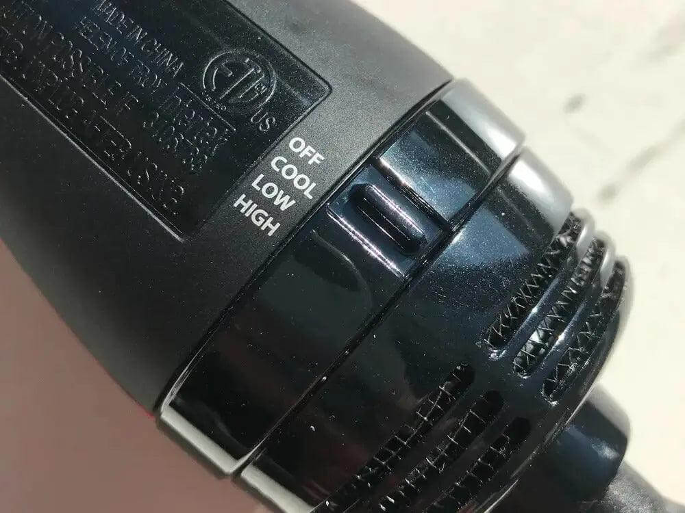 Close-up of Revlon One Step Dryer controls showing OFF, COOL, LOW, and HIGH settings for customizable styling.