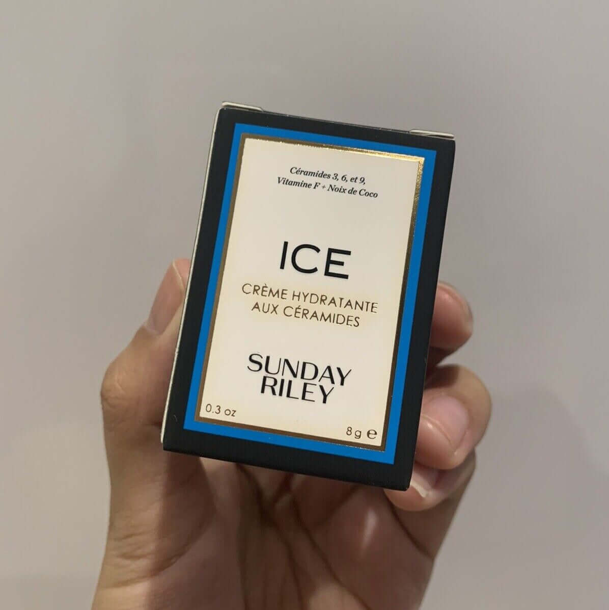 Sunday Riley ICE Ceramide Moisturizing Cream 8g packaging in hand, promoting luxury skincare and hydration.