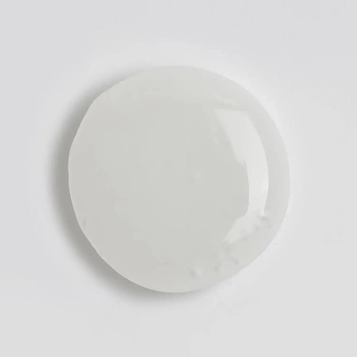 Clear, viscous drop of The INKEY List Polyglutamic Acid Serum on a white background.