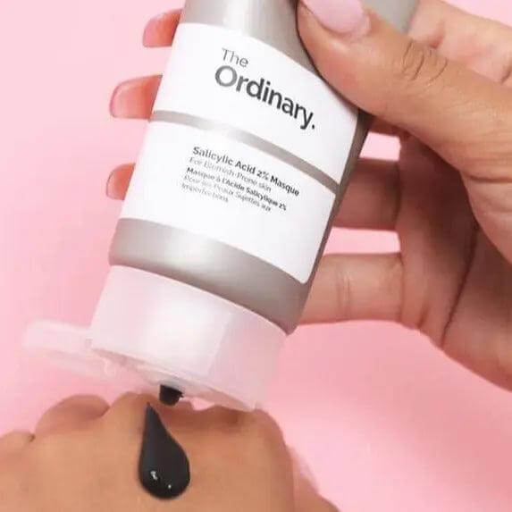 Application of The Ordinary Salicylic Acid 2% Masque on skin, showcasing its charcoal-infused formula for clearer complexion.